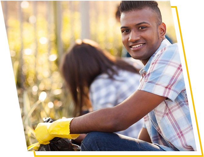 A man sitting on the ground wearing gloves.